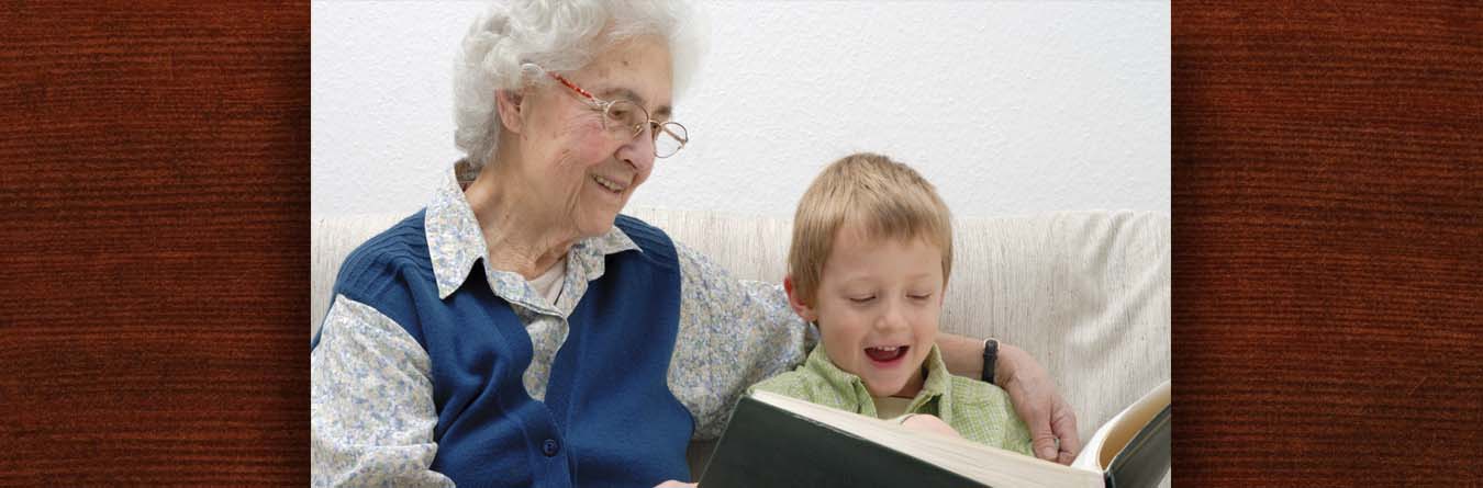 Woman and grandson read a book together.