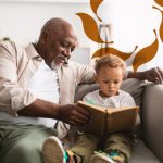 Cappella Pueblo West Senior Living Community in Pueblo West, CO - cappella pueblo west senior man reading with grandson