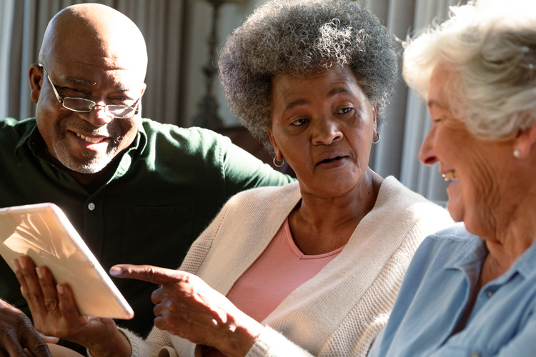 Cappella Pueblo West Senior Living Community in Pueblo West, CO - cappella of pueblo west senior adult group looking at tablet