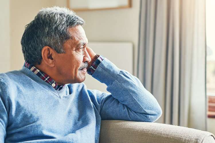 Cappella Pueblo West Senior Living Community in Pueblo West, CO - cappella pueblo west senior male looking out of window with depressed expression