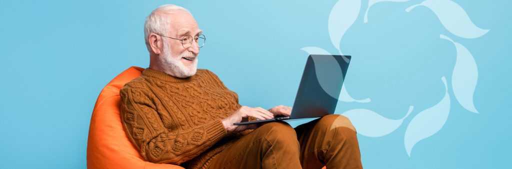 older man on beanbag chair with computer