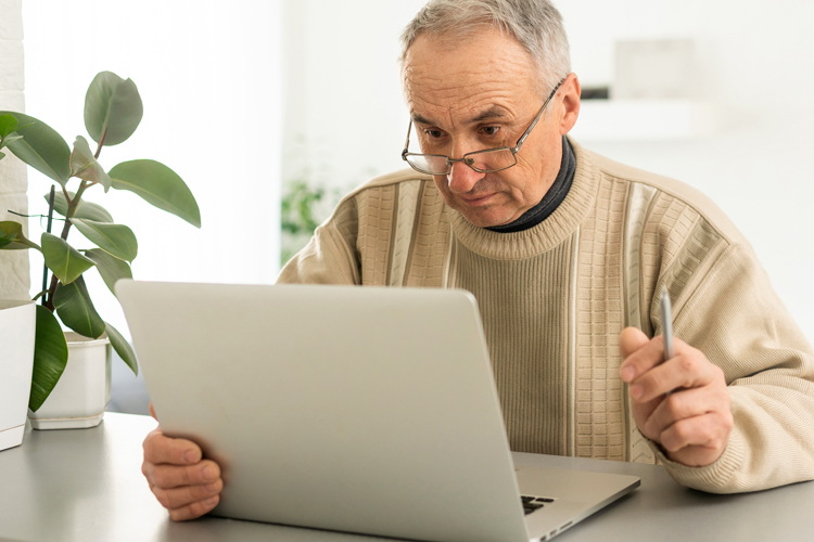 Cappella Pueblo West Senior Living Community in Pueblo West, CO - cappella of pueblo west senior man with laptop computer