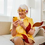 Cappella Pueblo West Senior Living Community in Pueblo West, CO - cappella of pueblo west senior woman with headphones and phone