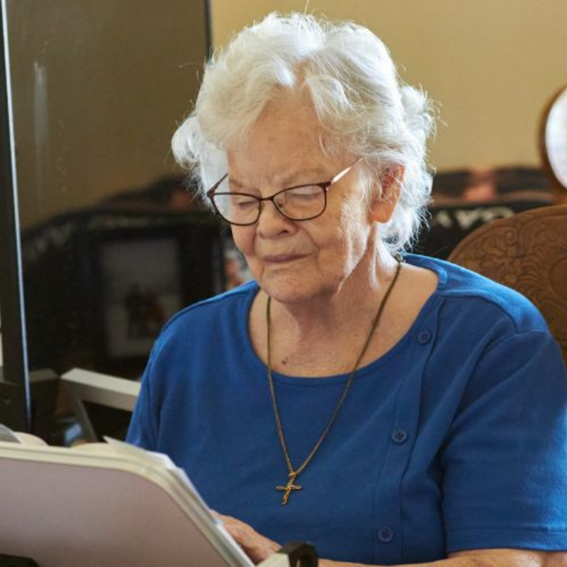 Cappella Pueblo West Senior Living Community in Pueblo West, CO - assisted living resident reading 4a square