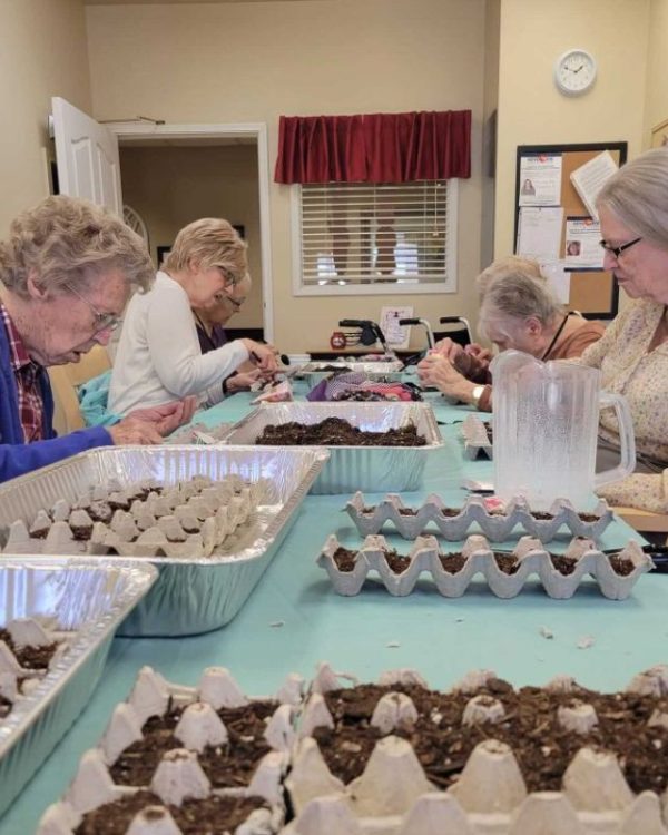 Cappella Pueblo West Senior Living Community in Pueblo West, CO - group of ladies planting seeds